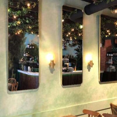 Agencement de la salle de restaurant avec de longs miroirs en laiton polis.