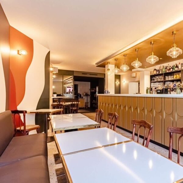 Bar du bistrot des Halles dans le style néo-rétro des anneés 20. Façade de comptoir avec motifs réguliers en relief. Piste de bar en pierre de lave. Ciel de bar avec suspentes des années folles.