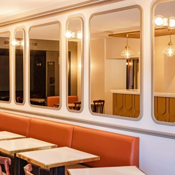 Décoration intérieur du Bistrot des Halles avec miroirs muraux aux angles arrondis et appliques art déco intégrées.