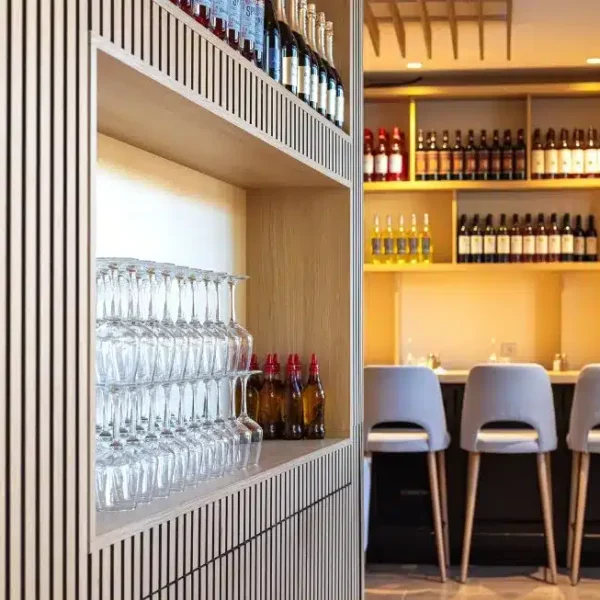 Zoom sur niches à verres intégrées dans l'habillage mural.