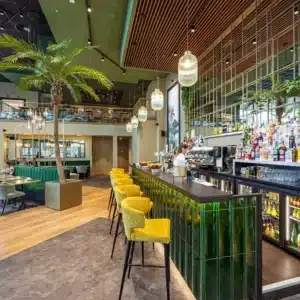 Vue latérale du bar avec espace convivial et mezzanine.