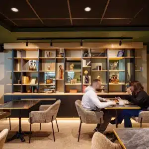 Espace lounge en mezzanine avec bibliothèque.