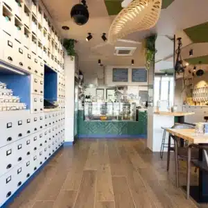 Aménagement intérieur du coffee shop ACAPELLA à Toulouse - comptoir et rangement muraux inspirés des anciens apothicaires.