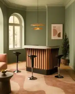 Intérieur salon contemporain chic avec comptoir de bar style art déco revisité avec dessus en étain et façade couleur terracotta et lames de bois foncé.