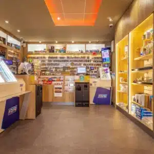 Vue du comptoir principal du Tabac Presse TOTEM à Plaisance-du-Touch, conçu sur mesure par Aranda-Mas avec mobilier bois clair, éclairage intégré et organisation optimisée des produits.