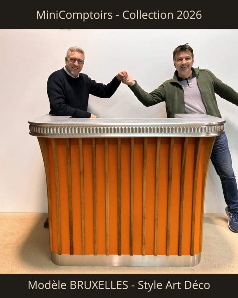 MiniComptoir façade orange de sienne avec lames de noyer massif, plinthe inox, dessus avec frise étain. Derrière 2 personnes des Etains de Lyon et Aranda-Mas qui se congratulent en se donnant la main.